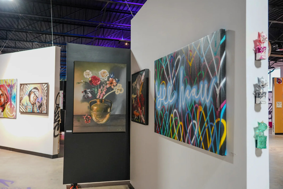 Original paintings and small sculptures displayed on freestanding walls inside Gallery DeFi
