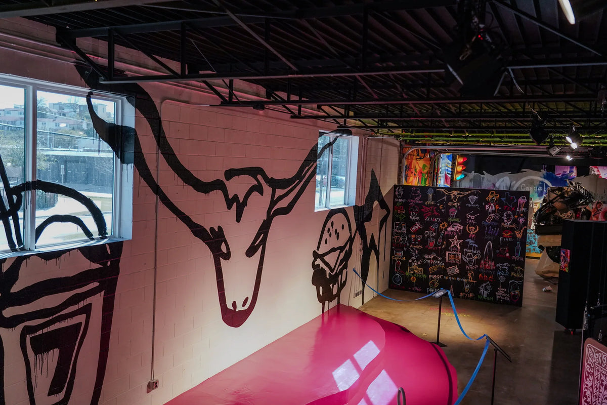 Large pink lip sculpture beneath black line drawings at Gallery DeFi