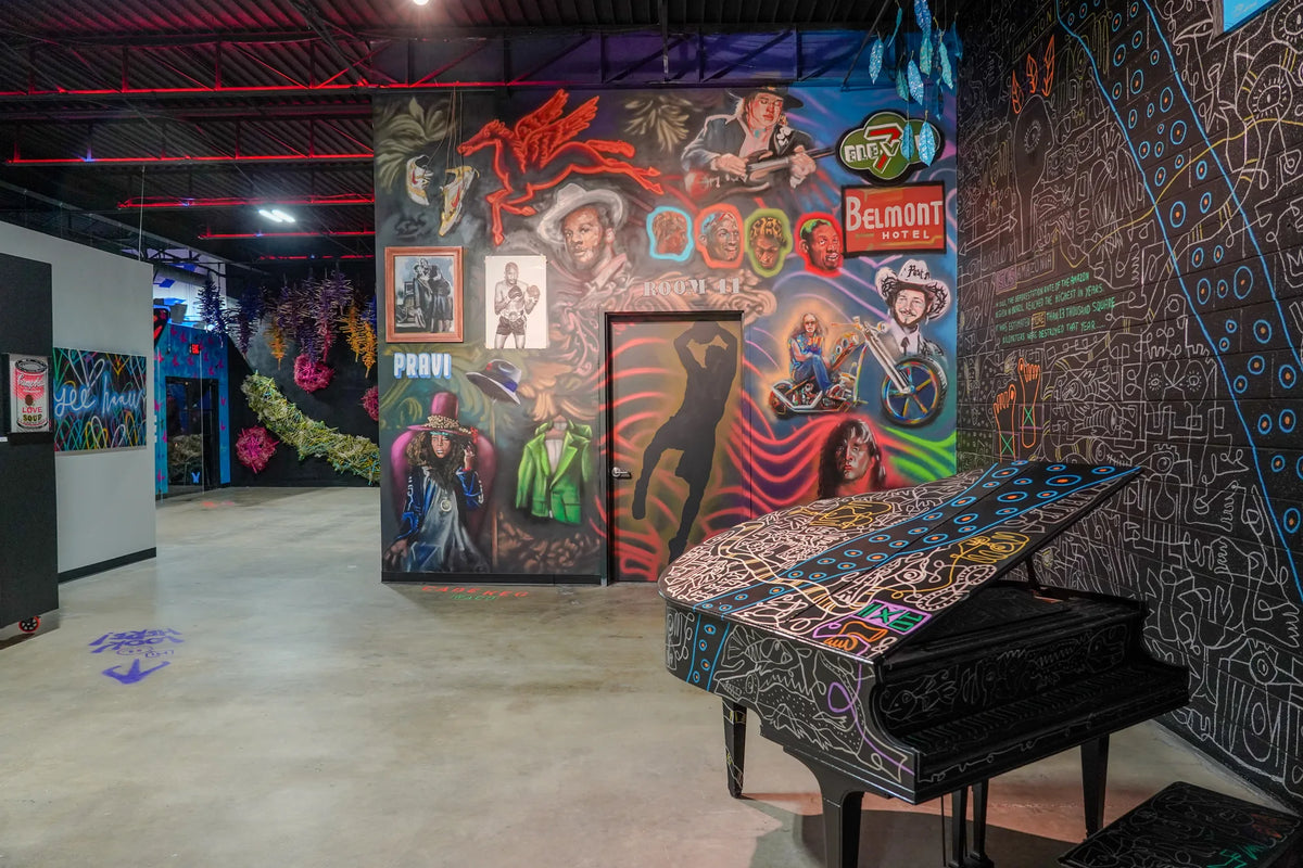 Painted grand piano beside murals and gallery walkways